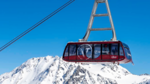 The Cime Caron cable car mid-journey above snowy peaks in Val Thorens