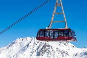 The Cime Caron cable car mid-journey above snowy peaks in Val Thorens
