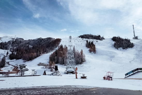 a ski hill in the early days of getting covered up with snow