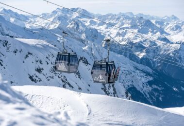 Roche de Mio Gondola cabins transporting skiers high above La Plagne’s alpine terrain.