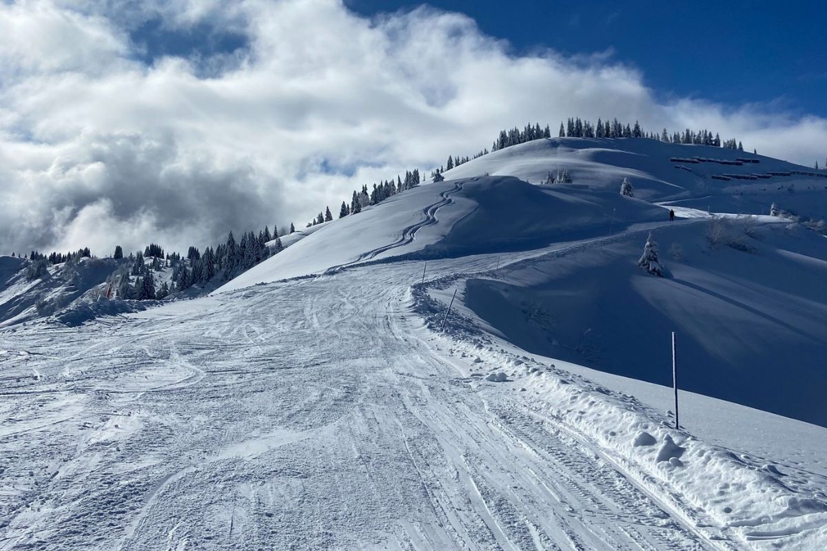 Fresh ski tracks on a quiet powder-covered ridge in La Giettaz