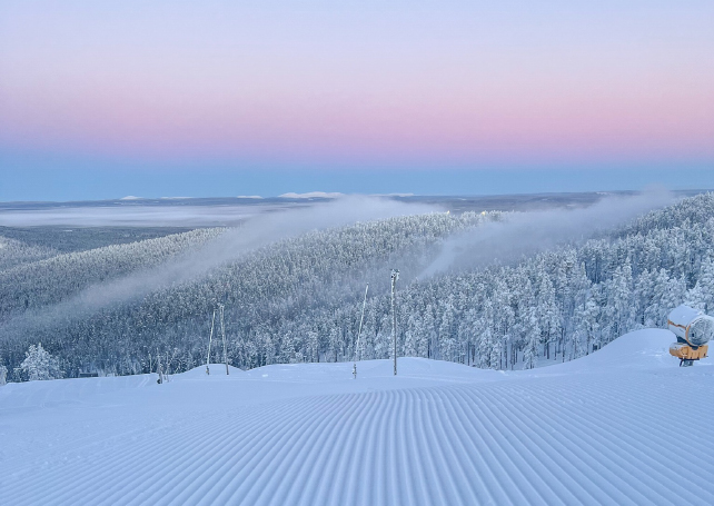 a pink sunset over a ski area