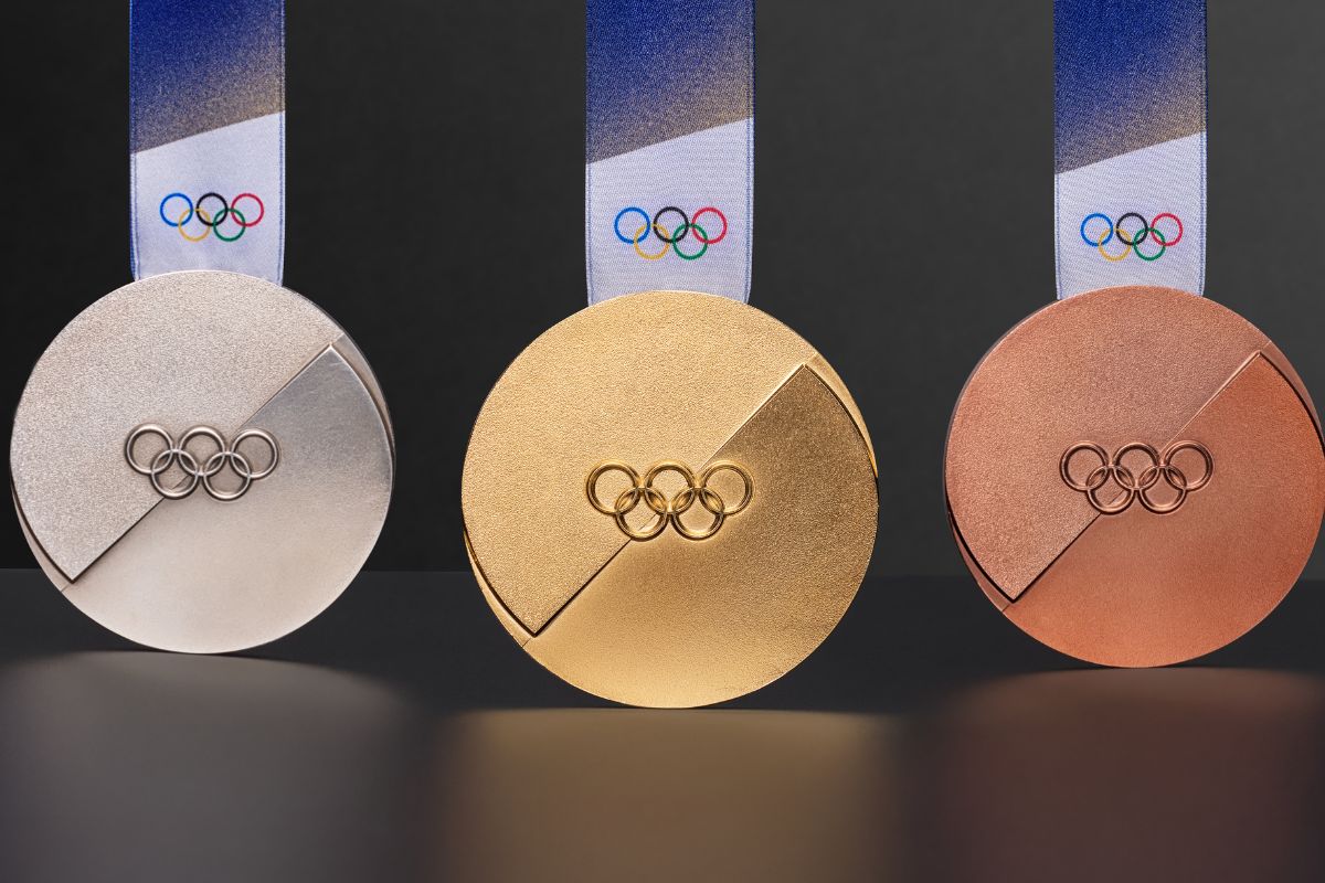 Gold, silver and bronze medals for the Milano Cortina 2026 Winter Olympics, shown with Olympic rings and textured design.
