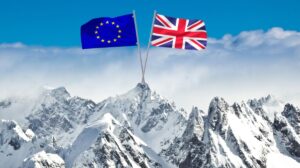EU and UK flags crossed over snowy Alpine mountains