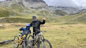 father and son by bikes in the green mountains, decked out for mountain biking