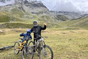 father and son by bikes in the green mountains, decked out for mountain biking