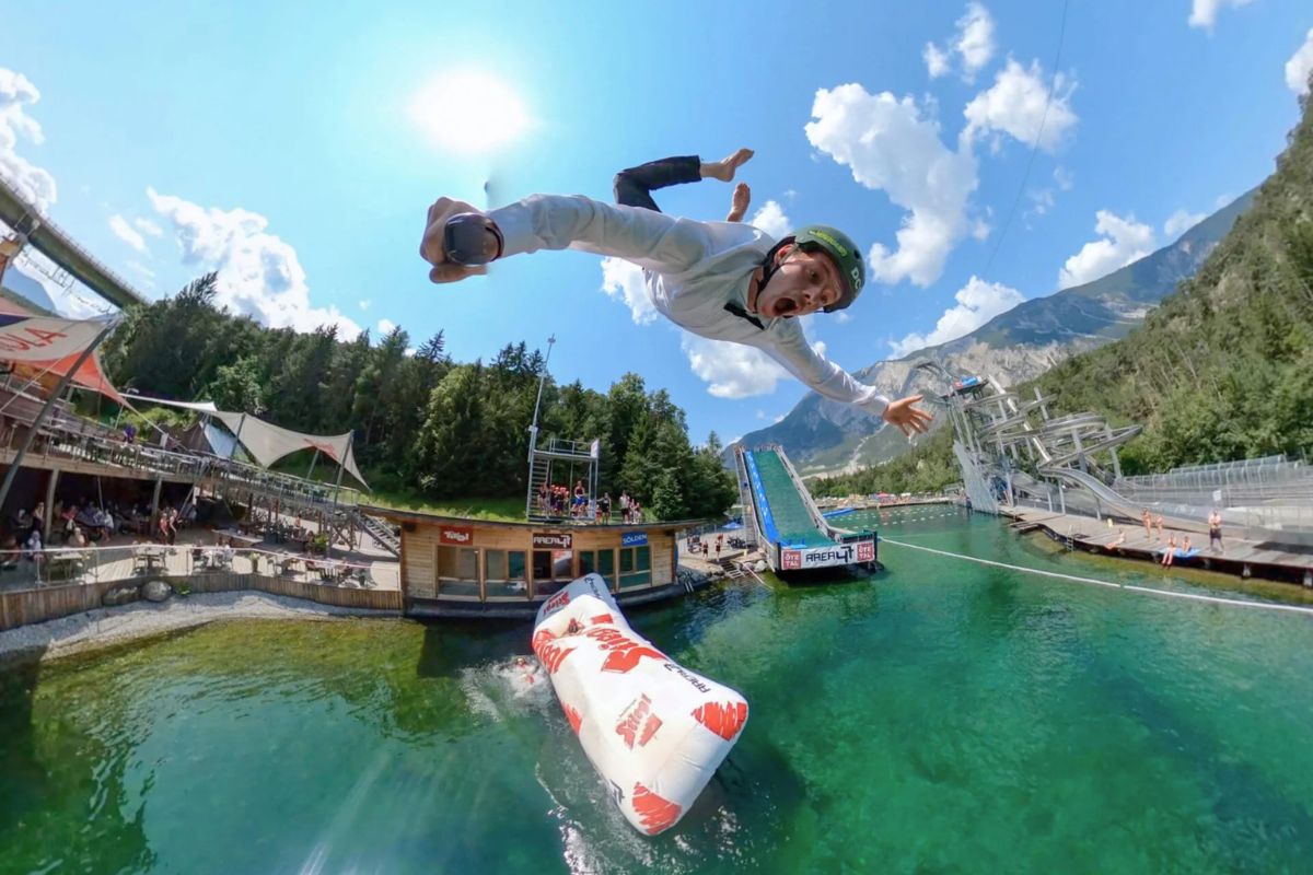 Man flying into the lake on a blob jump at Area 47 Alpine adventure theme park Austria