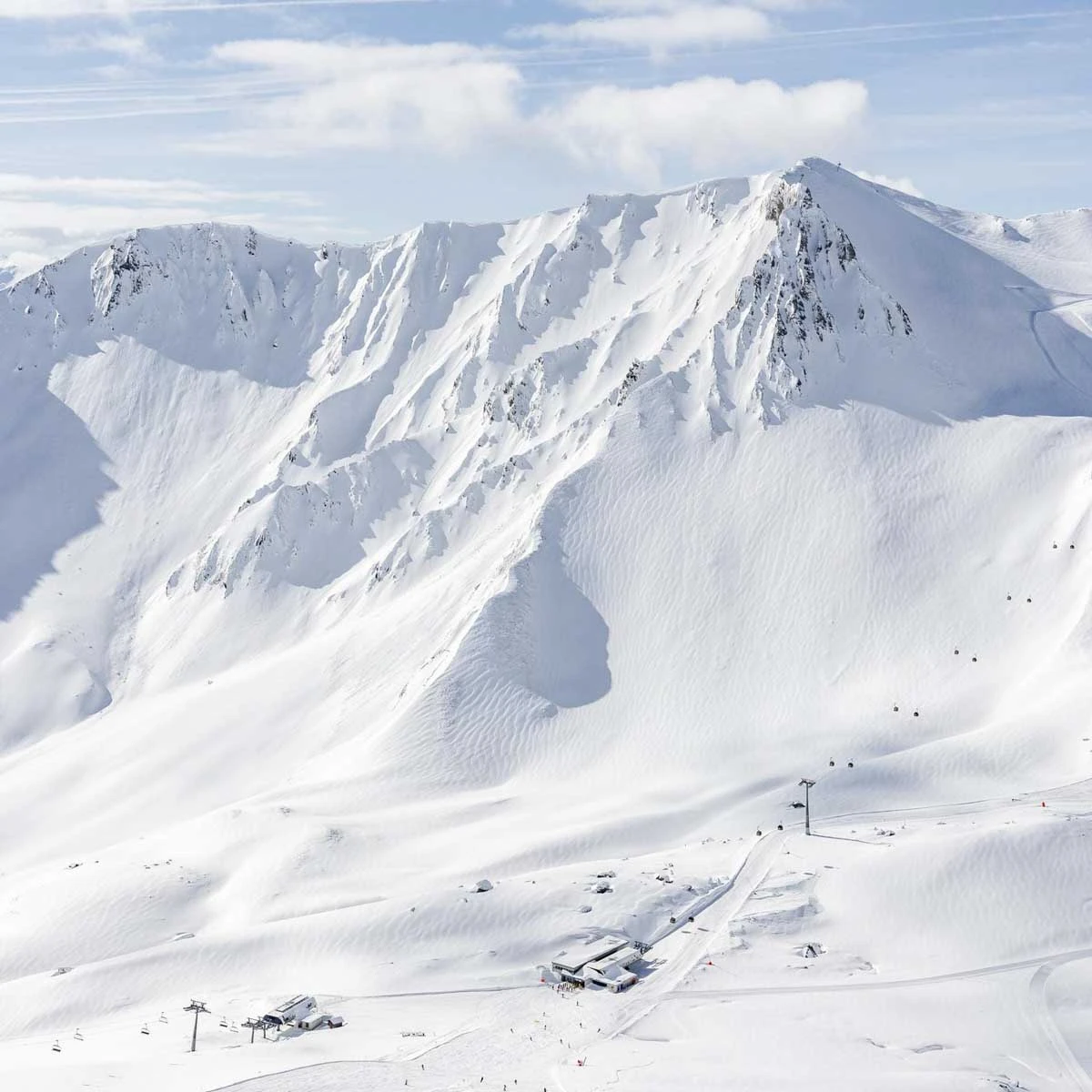 a beautifully white-blanketed high ski area pictured from afar