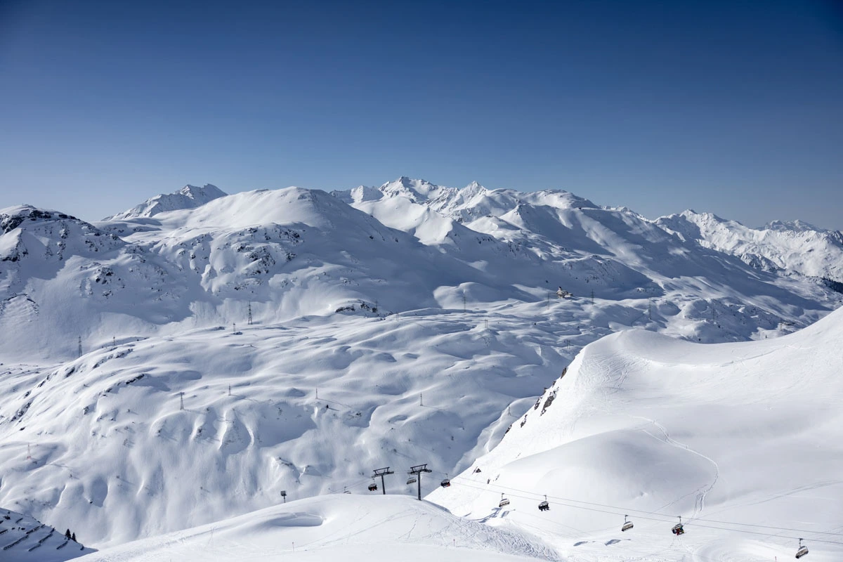 a pillowy scene of snow covering all topography, in a photo taken at the top of a mountain