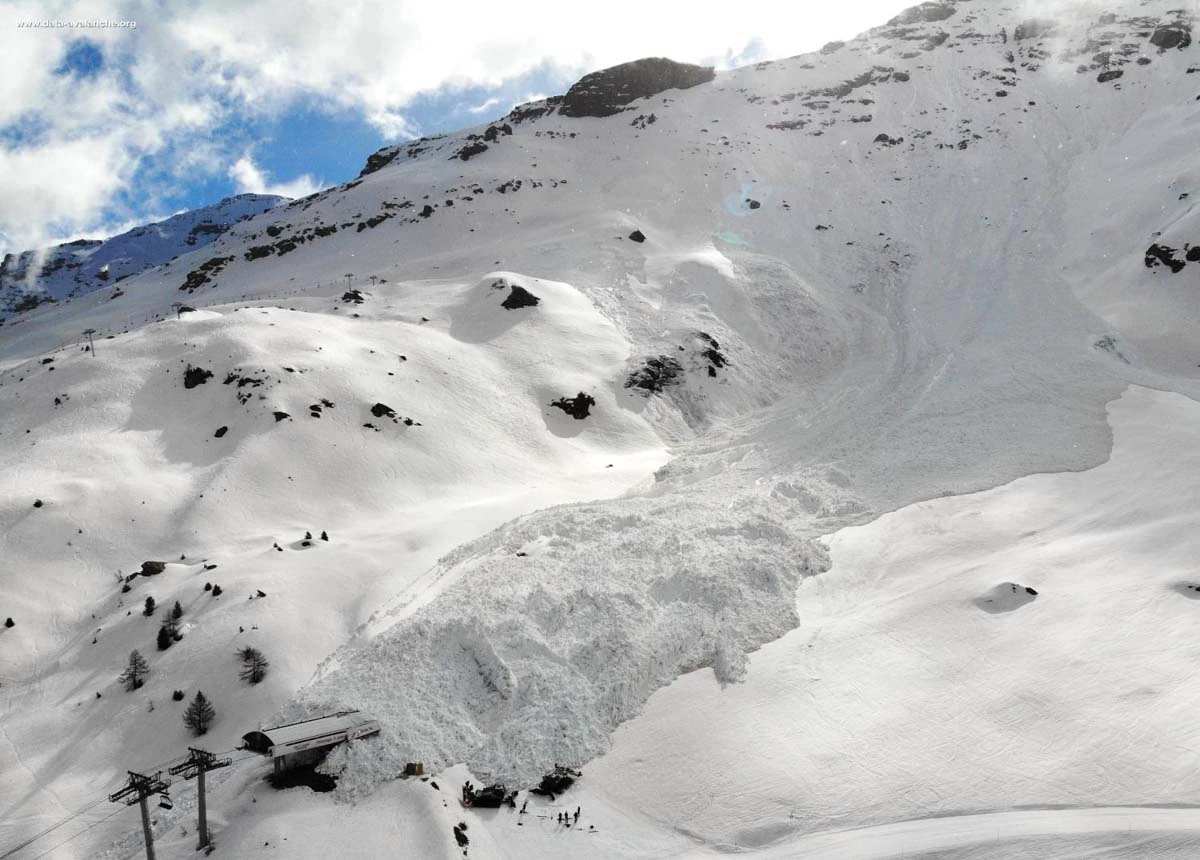avalanche aftermath scene, piling onto a top lift station - aerial shot