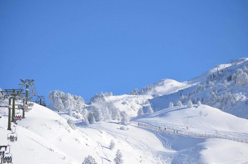 a fresh snow covering over a ski area under a blue sky