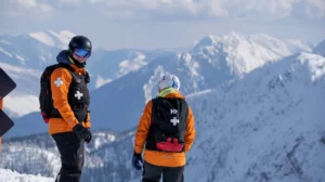 ski patrol in orange on the sunny mountain