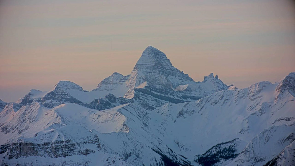 A huge mountain massif pictured against a pink light