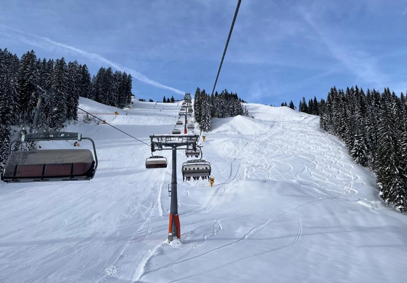 a chairlift line, with a piste to one side and fresh tracks off-piste to the other
