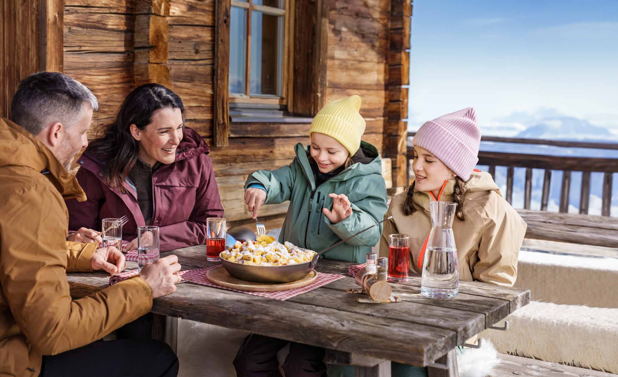 A family eating Kaiserschmarren (cut up pancake) at a mountain hut in Austria