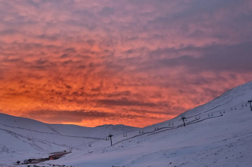 red sky over a chairlift on a Scottish hill