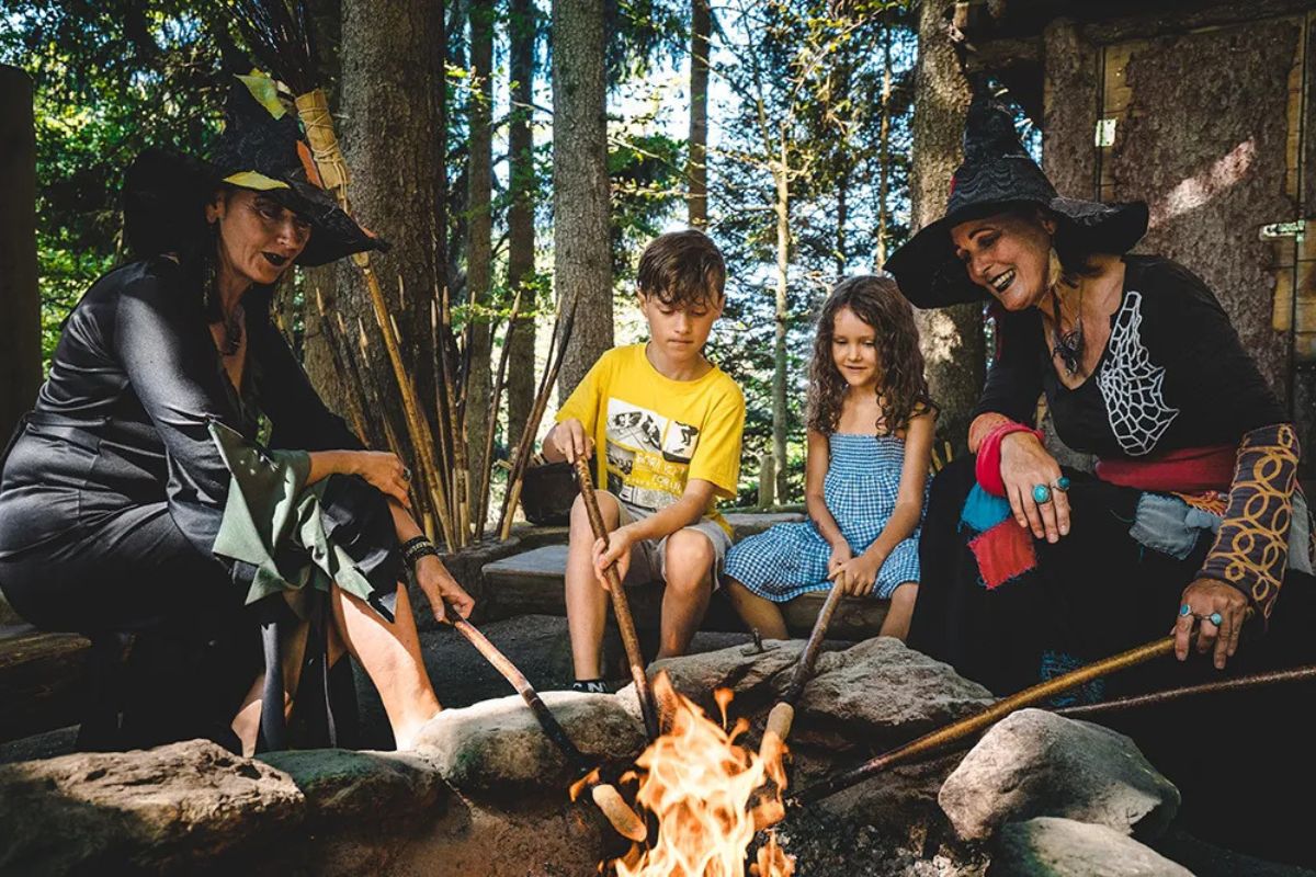 Children roasting bread with witches at Hexenwasser Alpine theme park in Austria