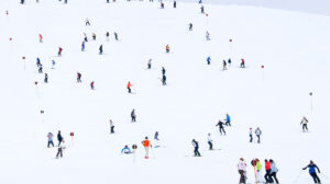 a white piste dotted with skiers