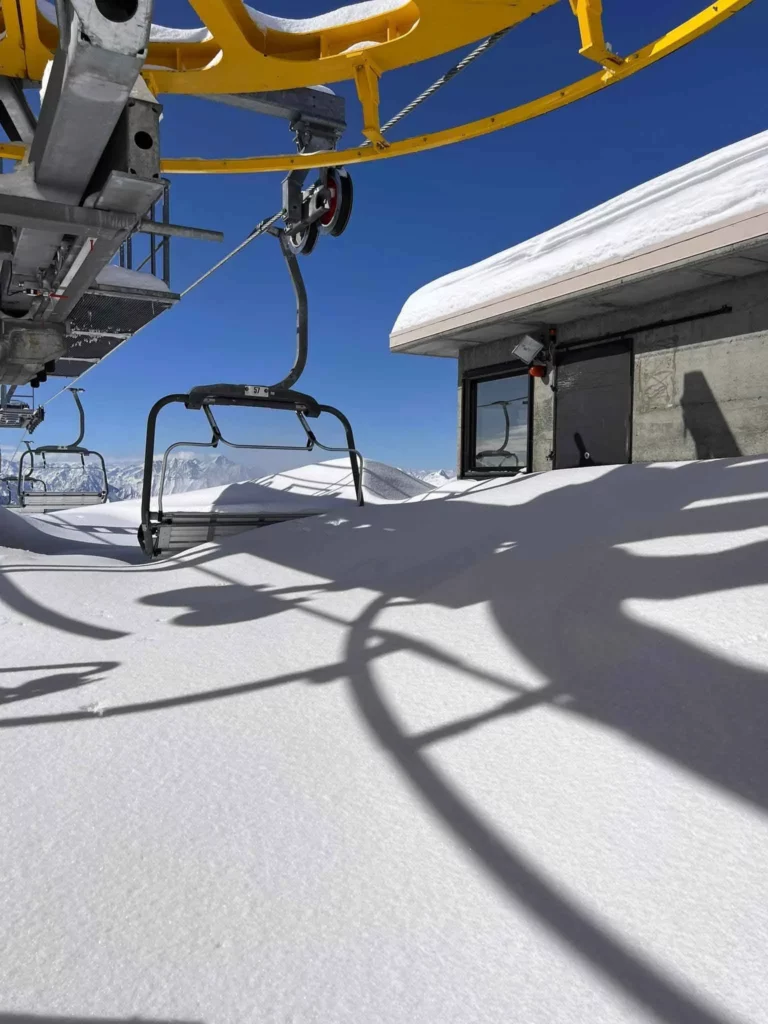 a chairlift buried in fresh snow in the top station of the lift