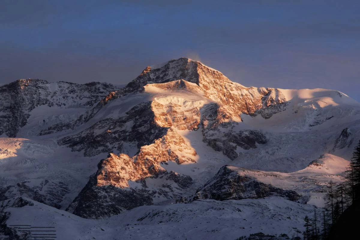 first light catches edges of a mountain massif