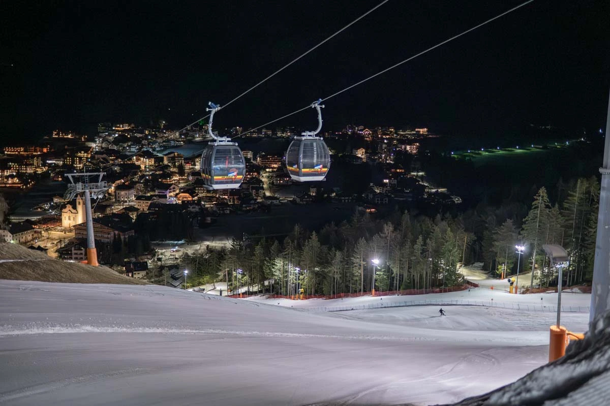 night skiing scenes on a blue-looking piste