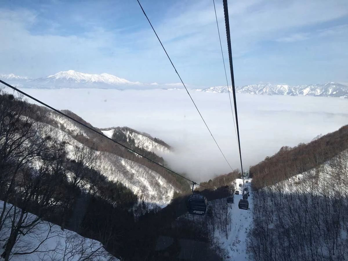 a gondola line, the valley below hidden by a sea of cloud