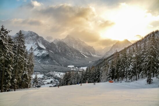 mountain sunset casts a golden glow over the ski area of Kronplatz