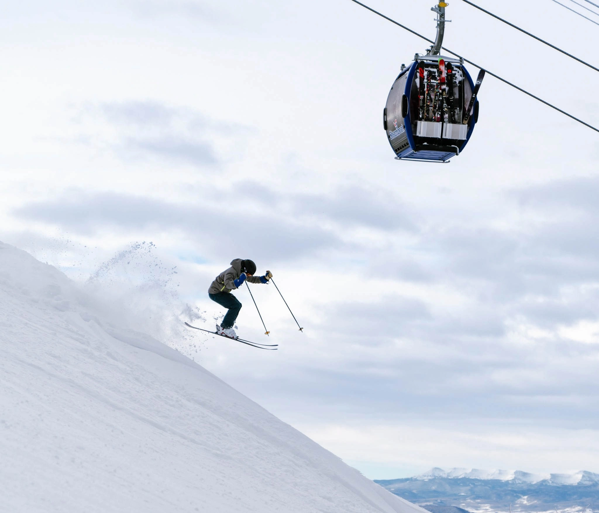 a skier takes a little air under a gondola