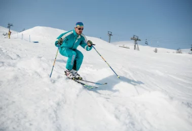 skier in retro gear tucks up, skiing bumps