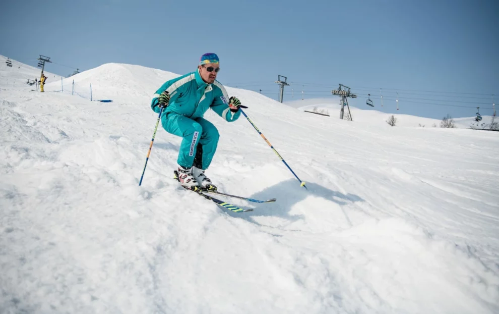 skier in retro gear tucks up, skiing bumps