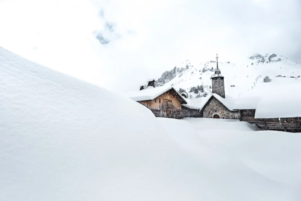 a church of a ski village under heavy snow