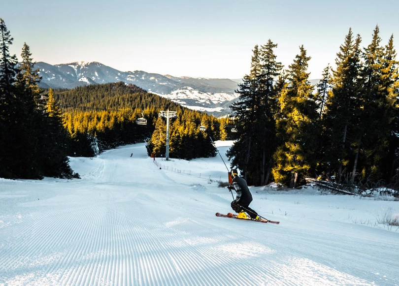 A racer-style skier on perfect corduroy piste through the alpine