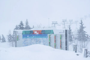 snow piling up against a piste map on snowy day