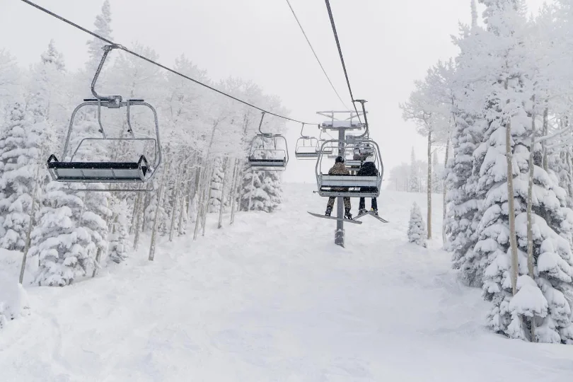 almost black and white picture, because of the snow and light, picturing a chairlift