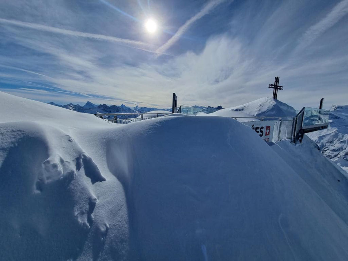 a cross at the top of a snowy mountain 