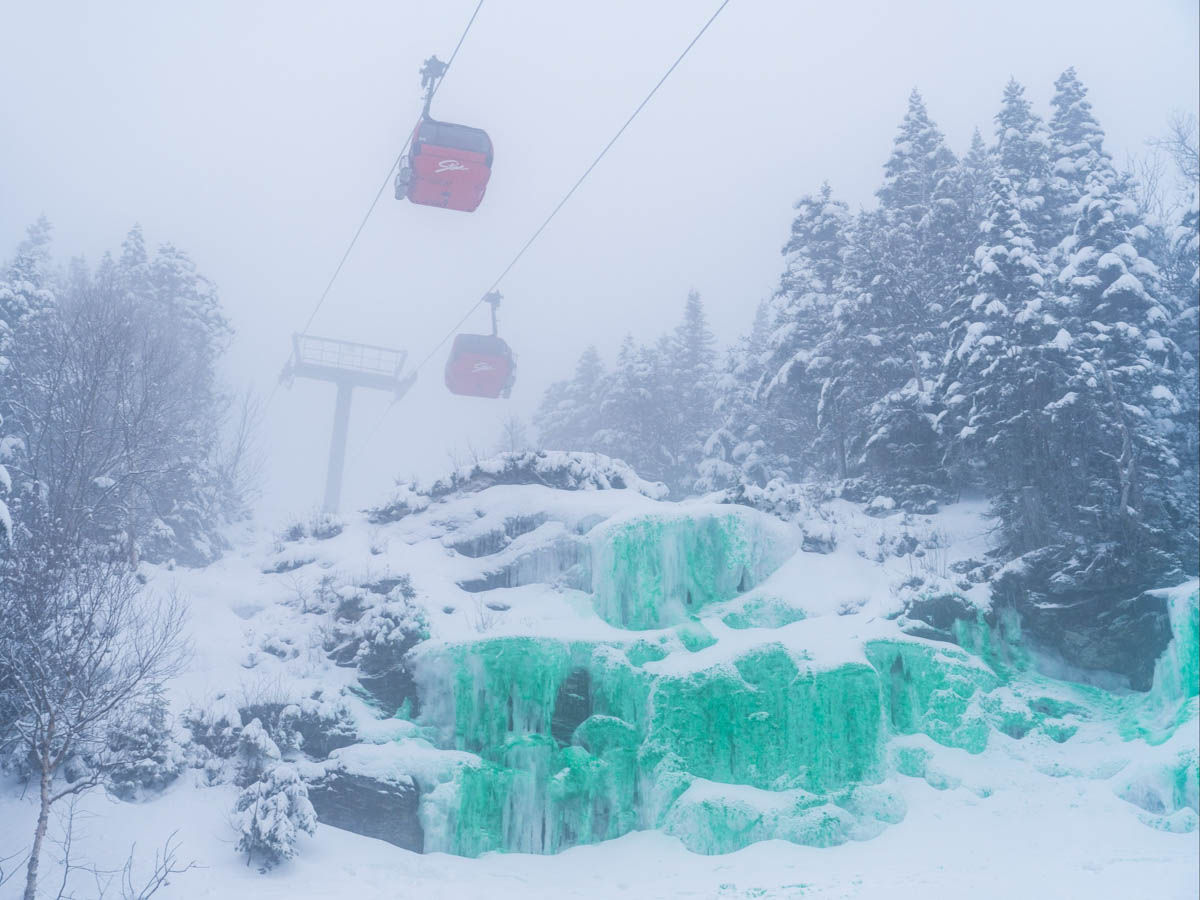 a green frozen waterfall under a red gondola on a snowy day (dyed green for St Patrick's day)