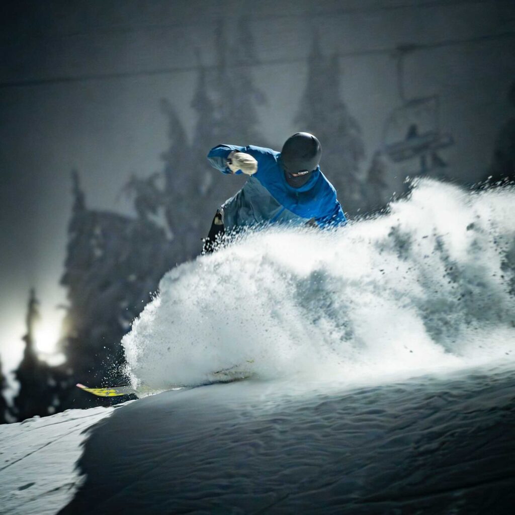 a snowboarder on fresh snow against a blurred background of a chairlift