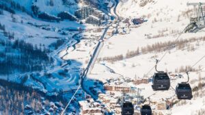 Scenic valley view of snow-covered mountains and village in Val d'Isère ski area.