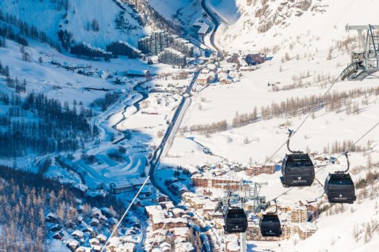 Scenic valley view of snow-covered mountains and village in Val d'Isère ski area.