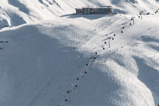 Ski slopes in Val d'Isère with gondolas transporting skiers up the snowy mountain.