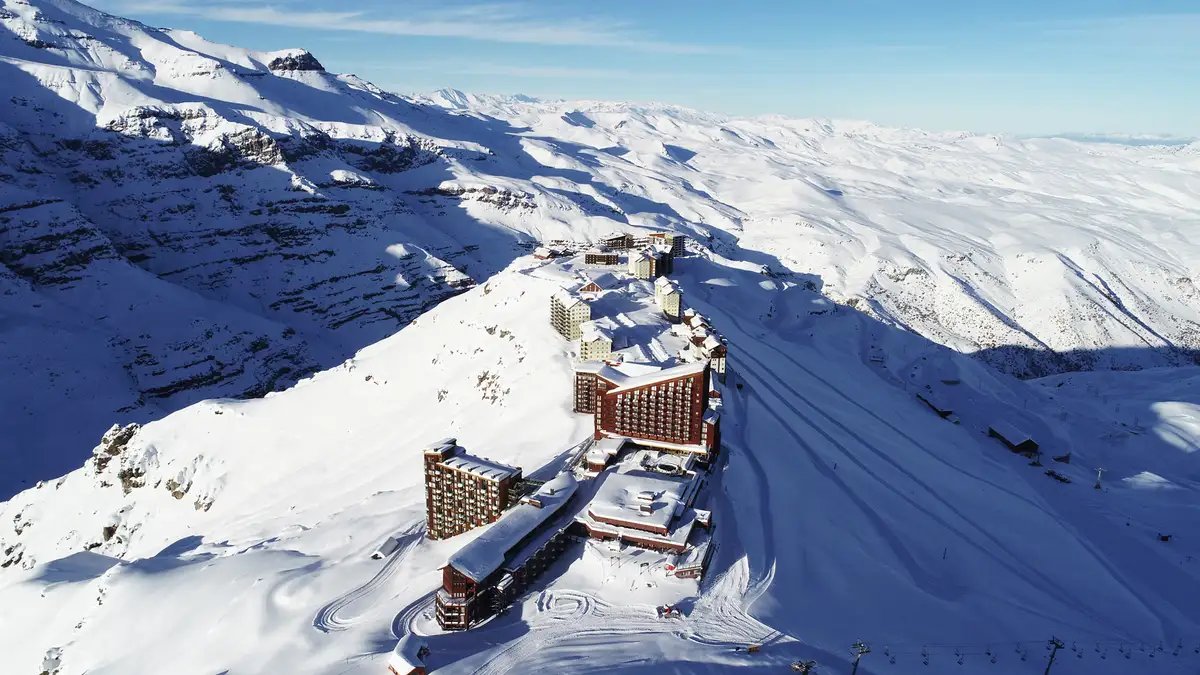 a high-altitude ski resort photographed surrounded by far-reaching white snow-covered mountains