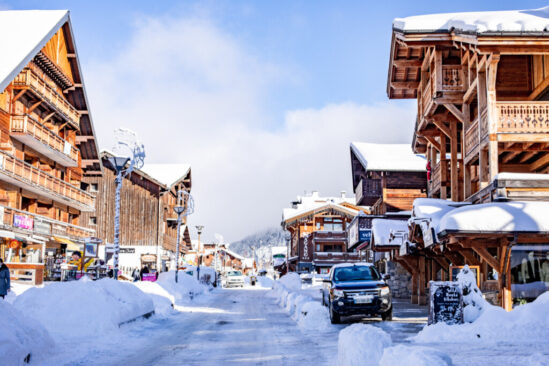 the main, snow covered street of les Gets, lined with wood chalets