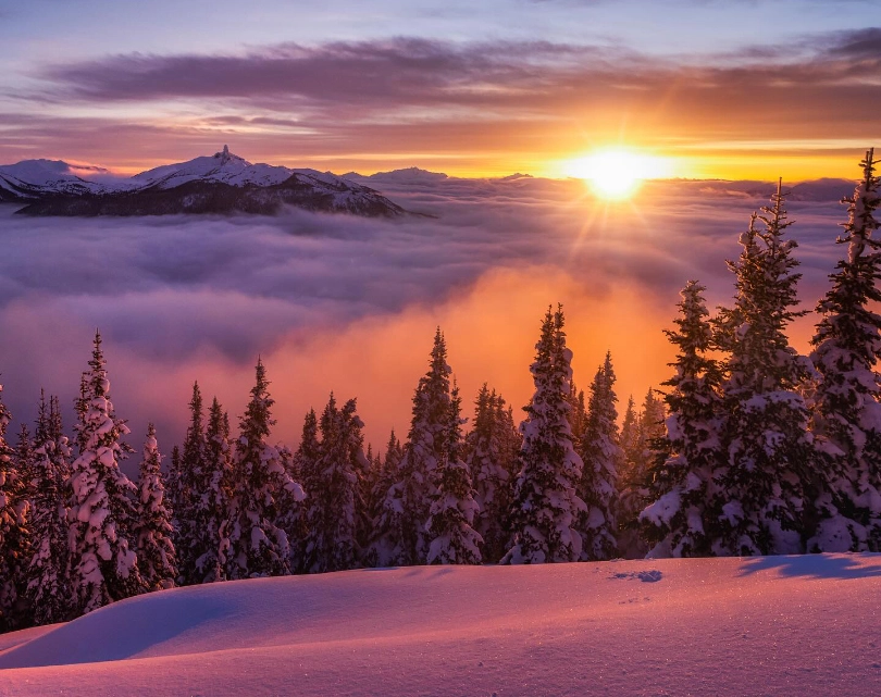 A beauty sunset above the clouds at the top of the mountain casts a purple glow on the snow